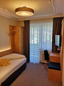 默尼希基兴蒂尔酒店的酒店客房配有一张床、一张书桌和一台电视。