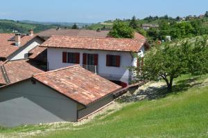 科斯蒂廖莱达斯蒂La Cascina dei Banditi的山坡上一座白色房子,屋顶红色