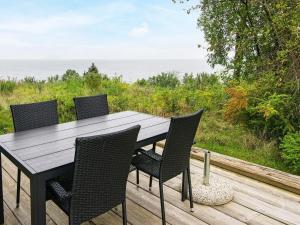 克内贝尔6 person holiday home in Knebel的甲板上的木桌和椅子,享有海景