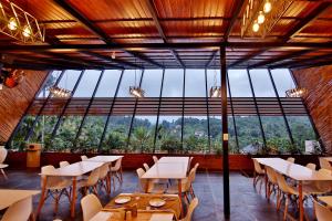 苏丹巴特利Le Villagio Resort & Domes的餐厅设有桌椅和大窗户。