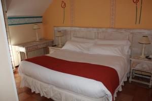 Alameda del ValleHotel La Posada De Alameda的卧室配有一张白色的大床和两张桌子
