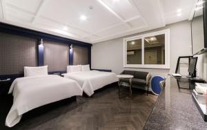 釜山Hotel French Code的酒店客房设有两张床和窗户。
