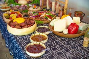 瑟利什泰Pensiunea Domnescu的一张桌子,上面放着不同种类的奶酪和其他食物