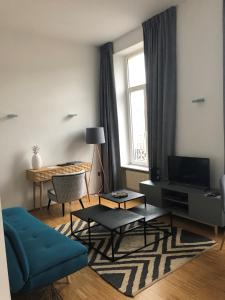 卢森堡沃邦酒店的客厅设有蓝色的沙发和窗户。