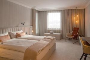 达沃斯孔格里斯酒店的酒店客房带一张大床和一把椅子