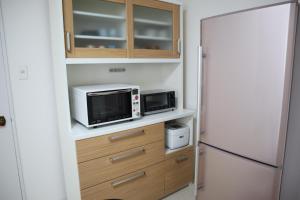 札幌STAY Moiwayama201的厨房配有微波炉和冰箱。