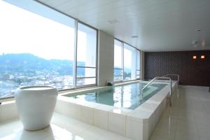 高山奥尔皮娜海达高山市Spa酒店的一座大型游泳池,位于一座带大窗户的建筑内
