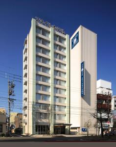 松山Smile Hotel Matsuyama的一座大建筑,上面有标志