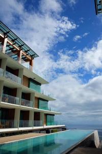 大雅台Escala Tagaytay的一座带游泳池的建筑,毗邻大海