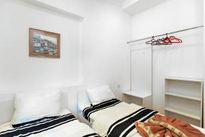 第比利斯31 Toidze Apartment的卧室配有两张床,墙上挂着一幅画