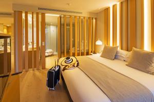 艾姆布里亚布拉瓦萨林斯港酒店的一间卧室配有一张大床,上面有行李箱