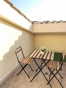 安圭拉萨巴齐亚REnt Room Wood的阳台上配有两把椅子和一张野餐桌