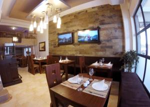 瓜亚基尔总统精品酒店的砖墙上设有桌椅和一台电视的餐厅