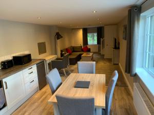 彻特西Fornham Guest House的厨房以及带桌椅的起居室。
