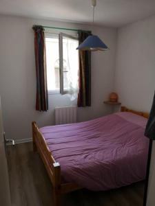 吕兹-圣索沃尔appart luz的一间卧室配有一张紫色床和窗户