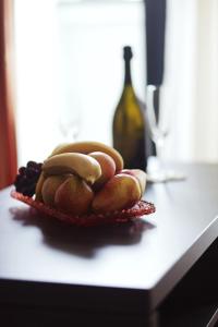泰斯利奇卡迪纳尔酒店的柜台上的一盘水果和一瓶葡萄酒