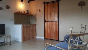 乌拉圭河畔康塞普西翁Antigua Fonda Duplex Studio的客厅设有木门和椅子