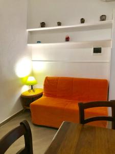 伊斯基亚Casette sul Porto的客厅里一张橙色的沙发,配有桌子