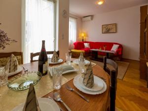 茨里克韦尼察Apartments Jasmina的一间带桌子和红色沙发的用餐室
