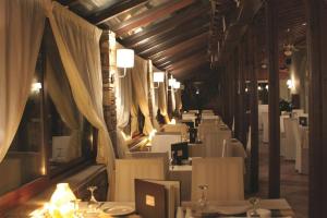 埃拉托克里昂神话酒店的用餐室配有白色的桌子和白色的椅子
