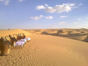 KūriSunny Desert Camp的沙漠中的一排桌椅