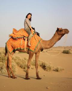 KūriSunny Desert Camp的骑骆驼的女人