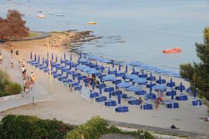 切萨雷奥港Hotel Royal - Beauty & Spa的海滩上摆放着蓝色的椅子和遮阳伞
