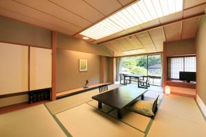 盛冈Shikitei Morioka TsunagiOnsen的客厅设有桌子和大窗户