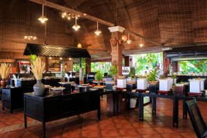 美奈Four Oceans Beach Resort - Bon Bien Mui Ne的一间餐厅,房间里摆放着桌子和植物