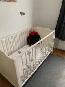 HeidkampLand-Ruhe的白色的婴儿床,上面有红色的背包