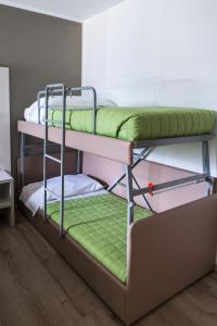TricesimoAlbergo Ristorante Belvedere的配有两张双层床的客房,配有绿色床单
