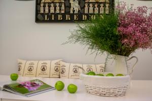 圣地亚哥－德孔波斯特拉Libredón Rooms的一张桌子,上面有一本书,花瓶和苹果