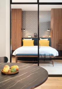 拉瓦勒Les Apparts de Marin的一间卧室设有两张床,桌子上放有水果盘