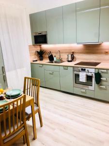 布拉迪斯拉发James Bond Apartment old town的厨房配有绿色橱柜和桌椅