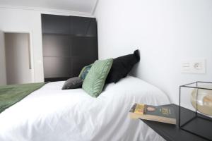 圣塞瓦斯蒂安SunSet Bastian Apartment的一间卧室配有一张白色的床和黑色床头板