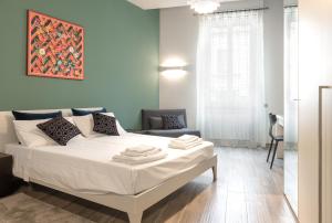 诺瓦拉B&B Mazzini15的卧室配有一张白色大床和一把椅子