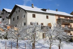 施库尔Il Maschun im historischen Engadinerhaus的前面有雪覆盖的树木的建筑