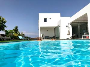 拉哈雷斯Turquesa 2 Fuerteventura的两人在房子前面的游泳池里