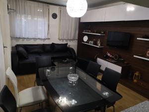 皮罗特Guest House Villa Krstic的客厅配有桌子和黑色沙发
