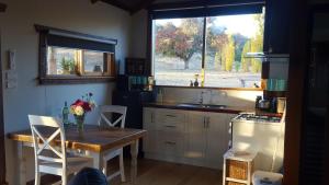 BarwiteBaroona Cottage的厨房配有桌子、水槽和窗户