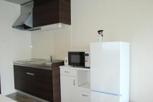 名户Gate in Nago的厨房配有白色冰箱和微波炉