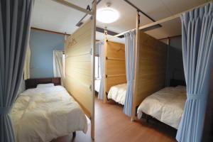 富山Guesthouse Iwase的一间卧室设有两张床,窗户配有窗帘