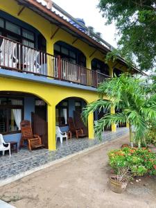 涛岛大海滩度假村的黄色的建筑,配有椅子和阳台