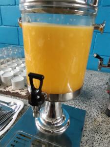 瓜鲁柳斯Cumbipar King Hotel的柜台上的搅拌机,上面装有橙汁