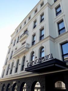 波德戈里察Boscovich Boutique Hotel的白色的建筑,上面有标志