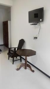 BatigamaWhite Lion Paradise Dikwella的椅子、桌子和墙上的电视