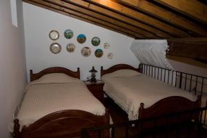 洛弗伊克尼奥斯别墅酒店的墙上挂有盘子的房间的两张床
