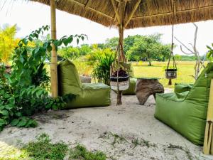 RindiEcoresort Sumba Dream的一个带吊床和小屋的户外庭院