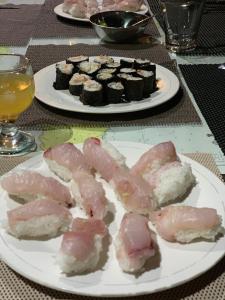 RindiEcoresort Sumba Dream的桌上的两盘肉和寿司
