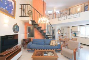 撒尼海滩Sani Beach Gallery Villa, your next family vacation!的客厅设有蓝色的沙发和楼梯。
